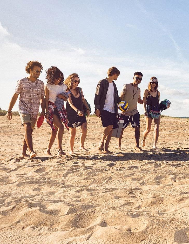 students walk on the sand on the beach